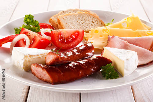 Breakfast - fried sausages, yellow cheese and vegetables 