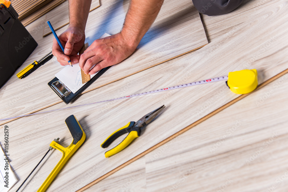 Man laying laminate flooring in construction concept Man laying laminate flooring in construction concept