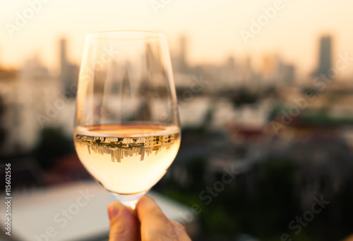 person enjoying a glass of wine and city view. 