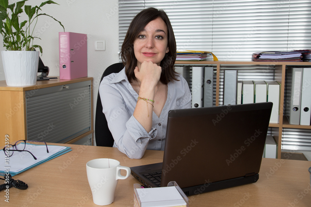 Portrait of businesswoman with laptop writes on a document Portrait of businesswoman with laptop writes on a document