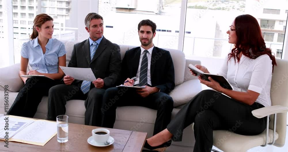 Business team sitting on couch having a meeting in the office