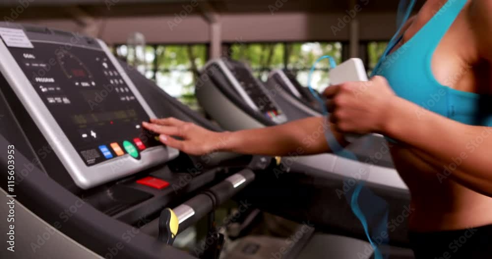 Smiling muscular woman running on treadmill Smiling muscular woman running on treadmill