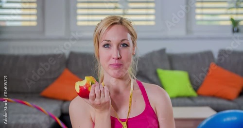 This girl is having a snack and is eating an apple. She's feelig good about herself and after a successful workout. Close-up shot.
 photo