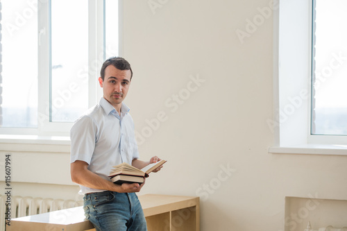 young male student reading books at class or living room