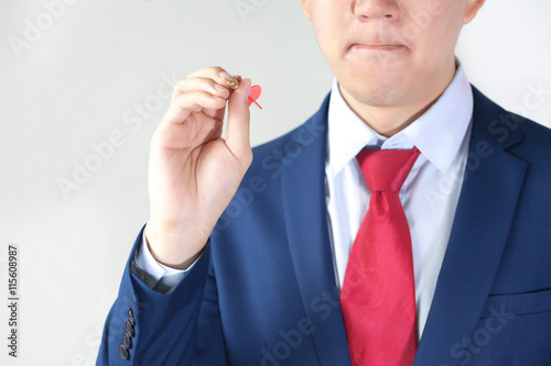 Businessman holding a dart aiming at the target - business targeting, marketing concept