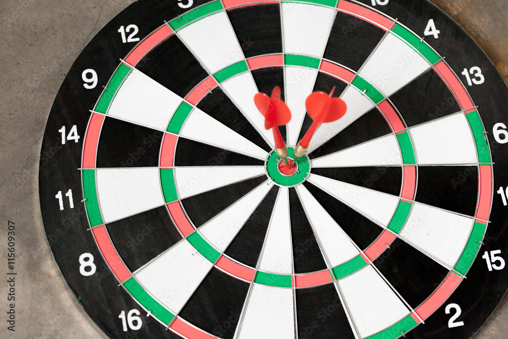 Darts accurately and perfectly hit the winning red spot on board (focus on center of the board) Darts accurately and perfectly hit the winning red spot on board (focus on center of the board)