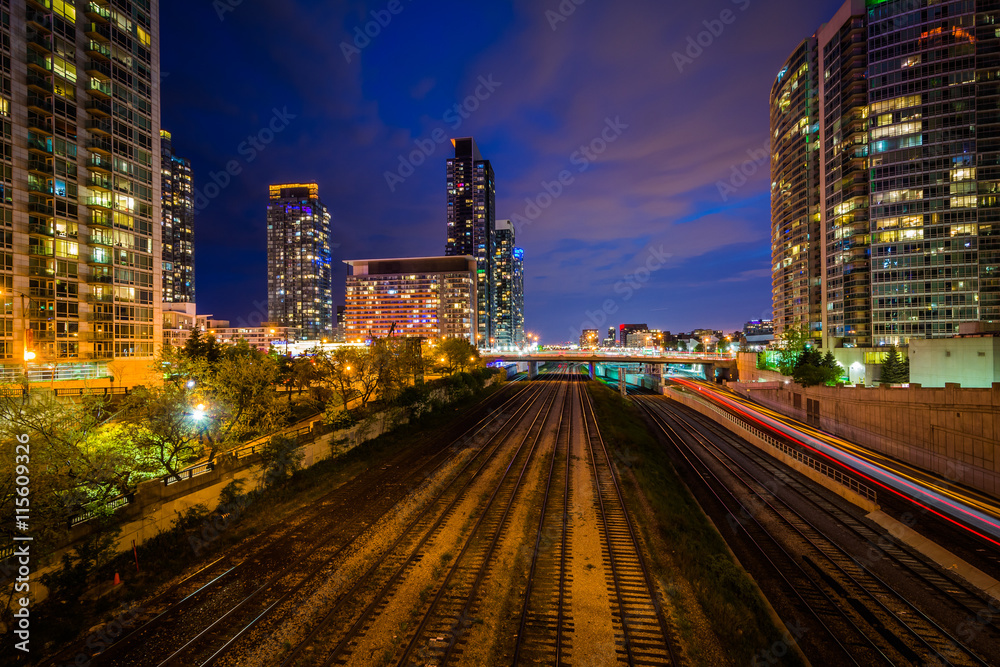 Obraz premium Railroad tracks and modern buildings at night, in downtown Toron