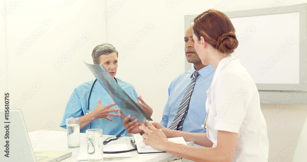 Team of doctors analyzing xray in medical office Team of doctors analyzing xray in medical office