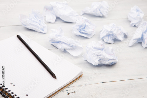 Creativity concept - notepad, pencil and crumpled paper on white