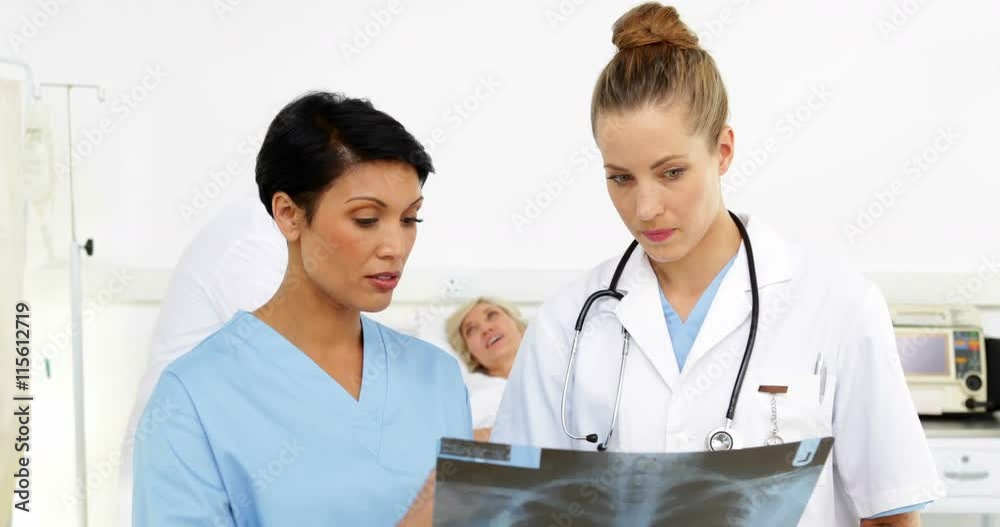 Doctor discussing in front of sick patient in bed Doctor discussing in front of sick patient in bed