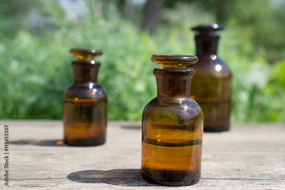 little brown bottles on wooden board and green grass