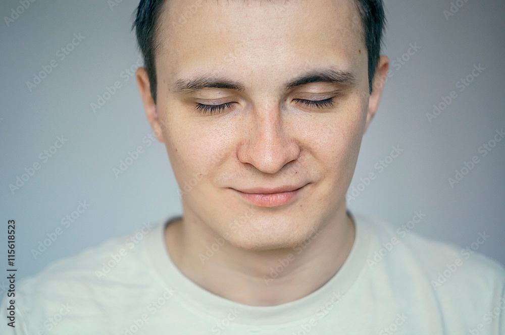 Portrait of young man with eyes closed in studio setting Portrait of young man with eyes closed in studio setting