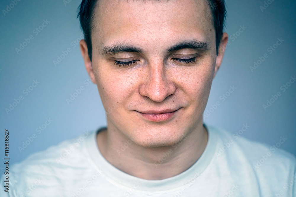 Fototapeta premium Closed eyes portrait of young man. Head and shoulders shot