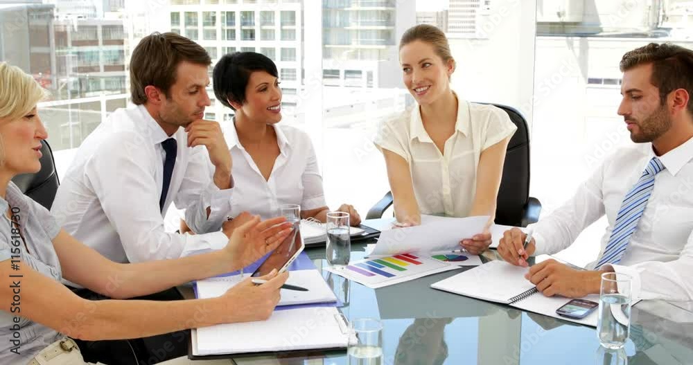 Happy business people going over figures at meeting Happy business people going over figures at meeting