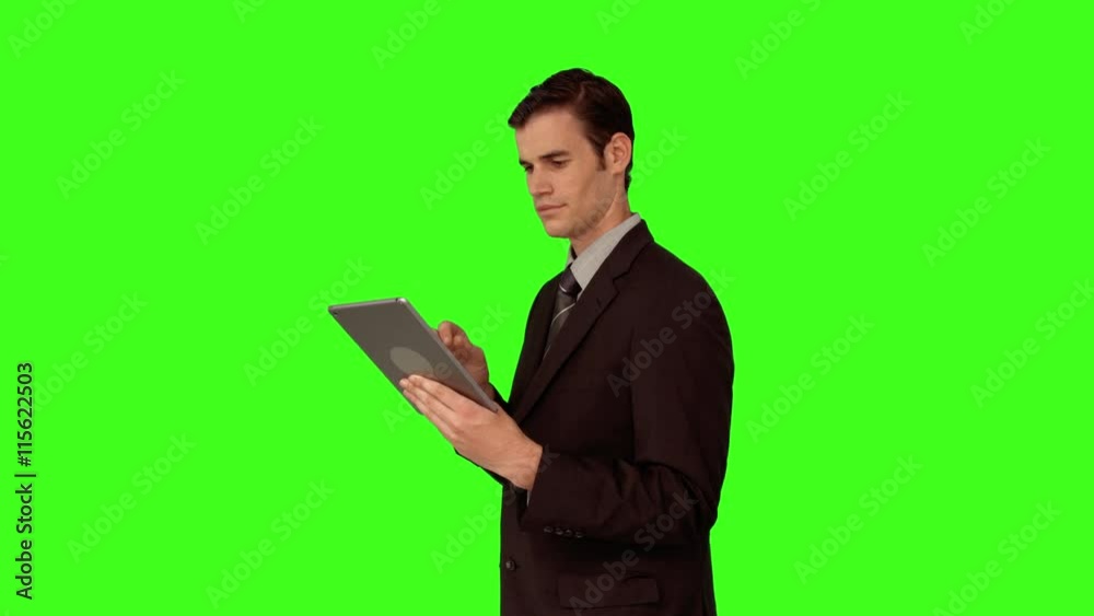 Businessman using his tablet pc on green screen background Businessman using his tablet pc on green screen background