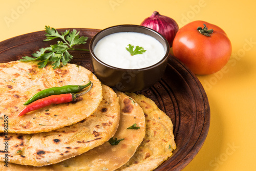 Traditional Indian bread - Aloo paratha or aalu parotha, potato stuffed bread. served with tomato ketchup or sauce and curd photo