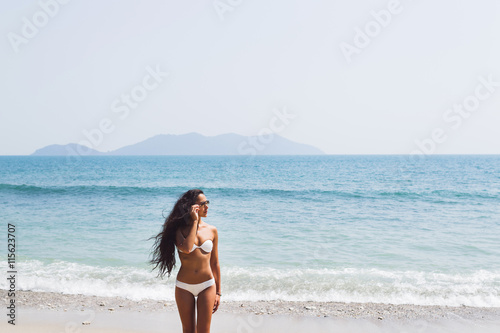 Beautiful thin woman with long black hair walking by the amazing