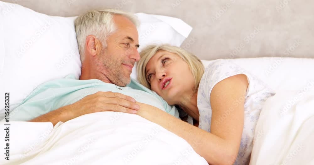 Couple chatting in bed and cuddling Couple chatting in bed and cuddling