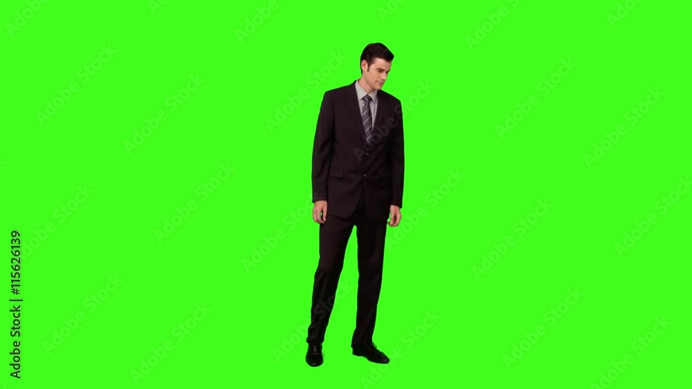 Businessman standing and looking down on green screen background Businessman standing and looking down on green screen background