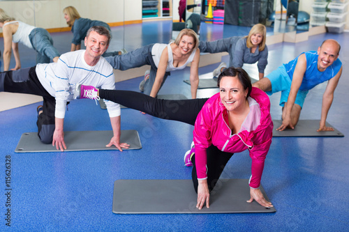 Group of mature people exercising on sport mats
