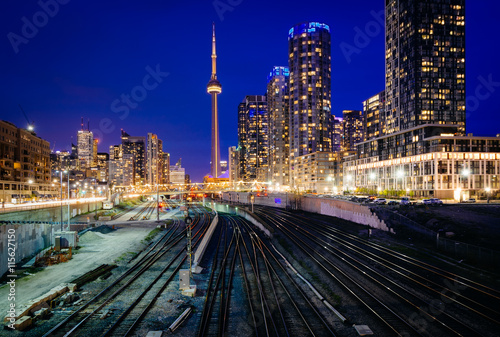 Photography View of a rail yard and modern buildings in downtown at night, f