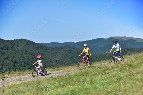 Parents with kids riding bikes in moutain path