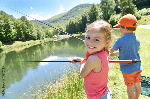 Portrait of little girl fishing by mountain lake