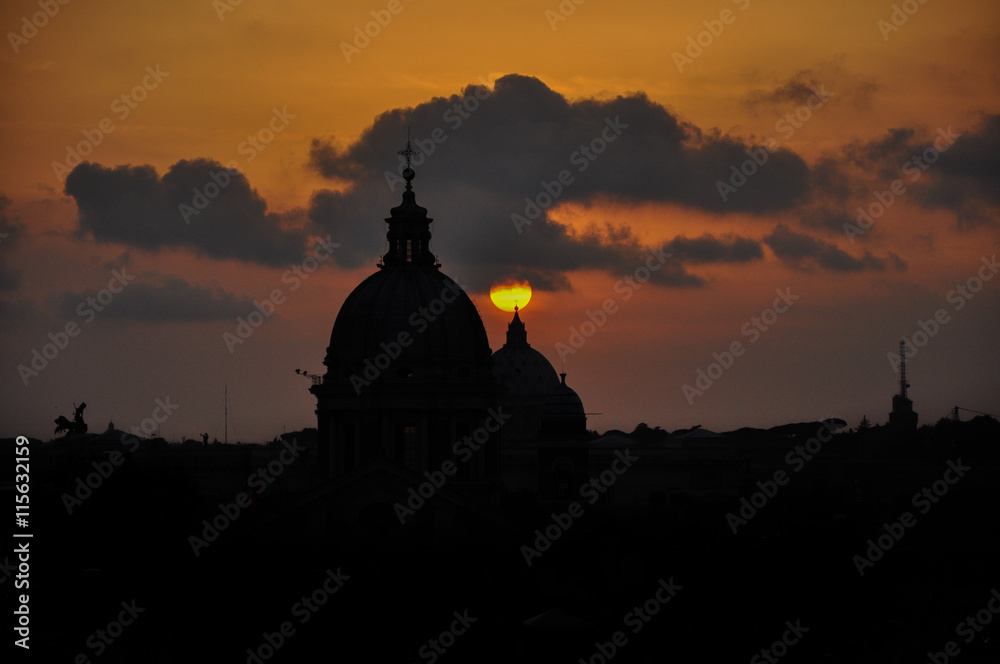 Puesta de sol en la cúpula del  Vaticano en Roma