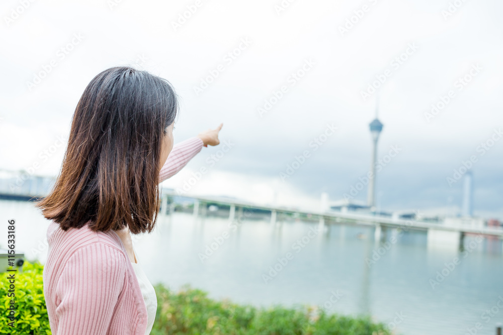Fototapeta premium Woman travel in Macao city and finger pointing to the tower