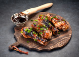Fried chicken legs with teriyaki sauce on a wooden board