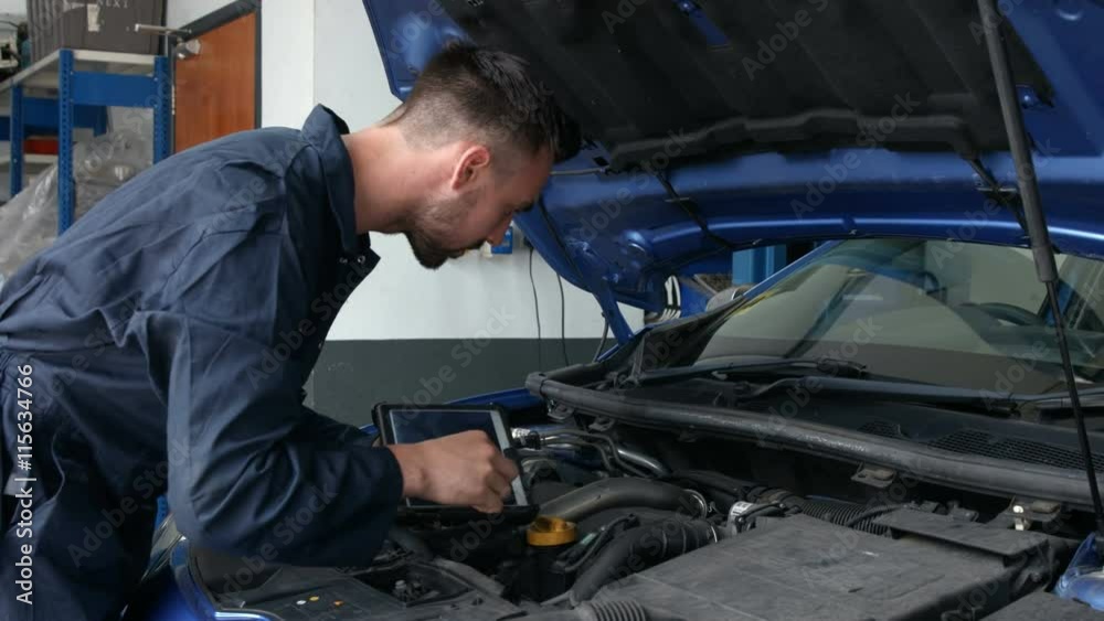 Mechanic overhauling an engine in the garage Mechanic overhauling an engine in the garage