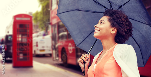 Photography happy african woman with umbrella in london city