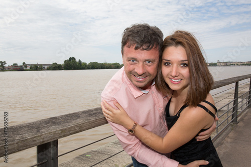 Beautiful young loving couple at the quayside with smile
