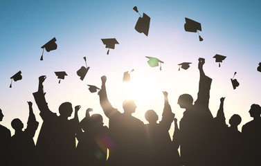 silhouettes of students throwing mortarboards