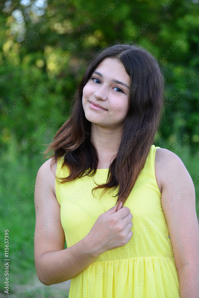 teen girl 15 years in yellow dress on nature