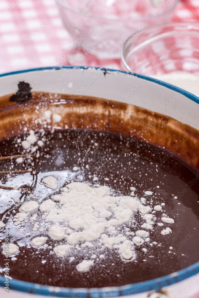 Mixing flour with melted chocolate cream Mixing flour with melted chocolate cream