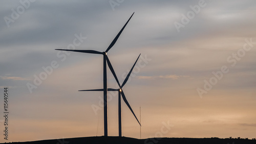 Wind turbine generator silhouette with twilight sky background. 