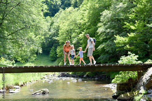 Photos Family of four walking on a bridge crossing the river