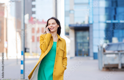 smiling young woman or girl calling on smartphone