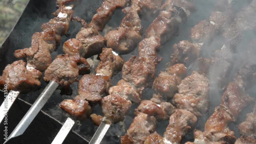 Meat rotating on a skewer. Close up of food grilling on barbecue. Meat rotating on a skewer. Close up of food grilling on barbecue.