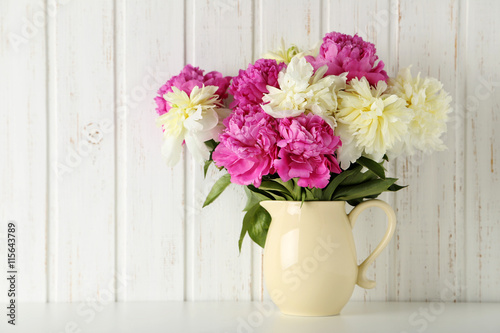 Bouquet of pink and white peony flowers on wal panelling backgro