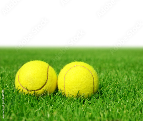 Two tennis balls in the green grass. © vencav