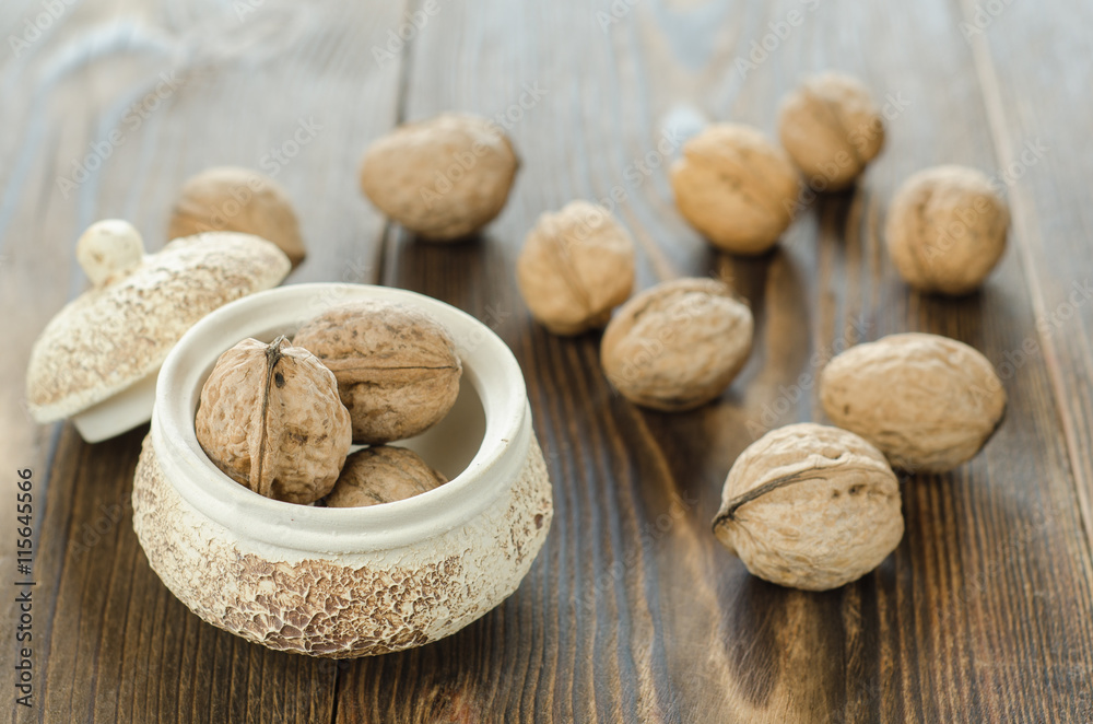 Walnut kernels and whole walnuts on wooden table Walnut kernels and whole walnuts on wooden table