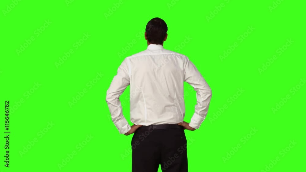 Businessman standing with hands on hips on green screen background