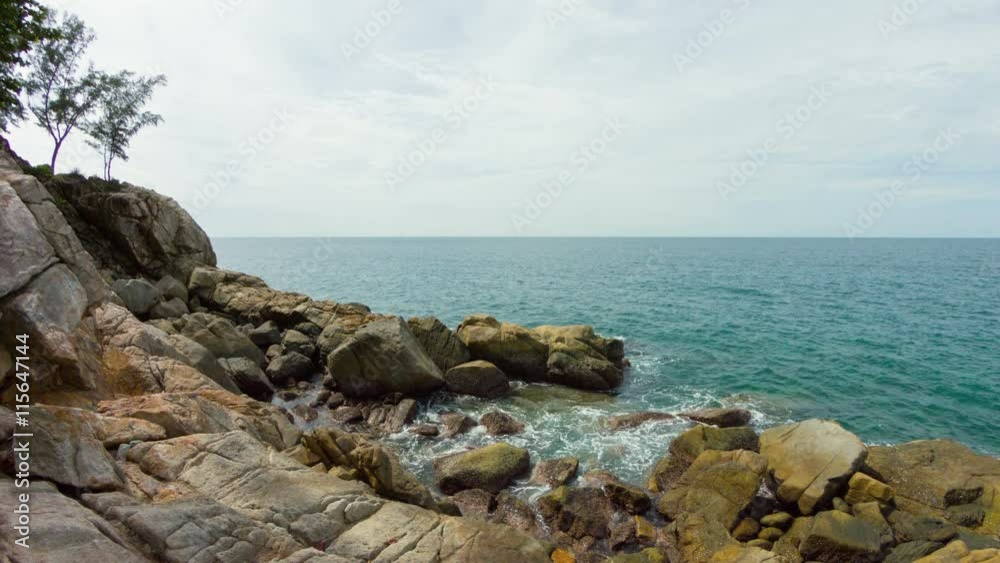Gray sky horizon against the warm water of a tropical sea, with enormous boulders of a rocky beach in the foreground. UHD video Gray sky horizon against the warm water of a tropical sea, with enormous boulders of a rocky beach in the foreground. UHD video