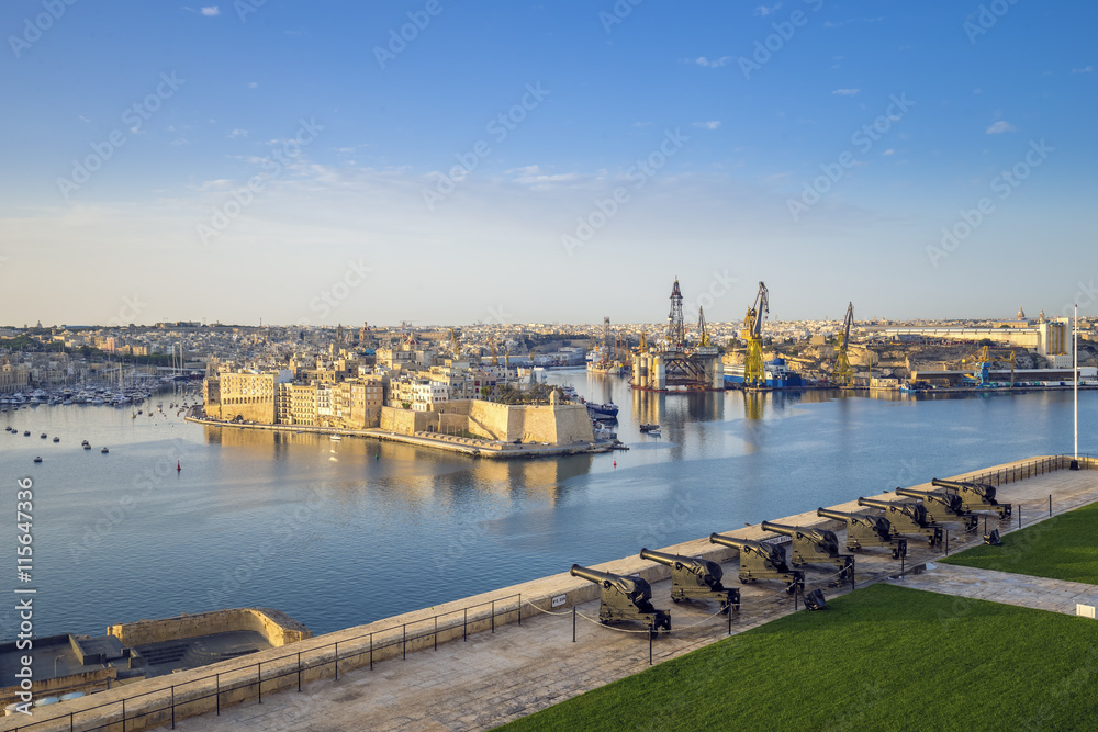 Skyline view of the Grand Harbour and Saluting Battery cannons with Senglea and docks at background, Valletta - Malta