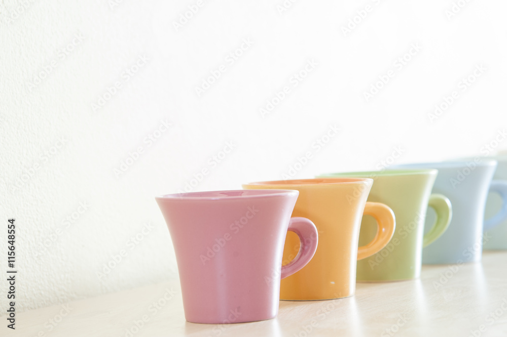 Row of colorful coffee cups on clear background.