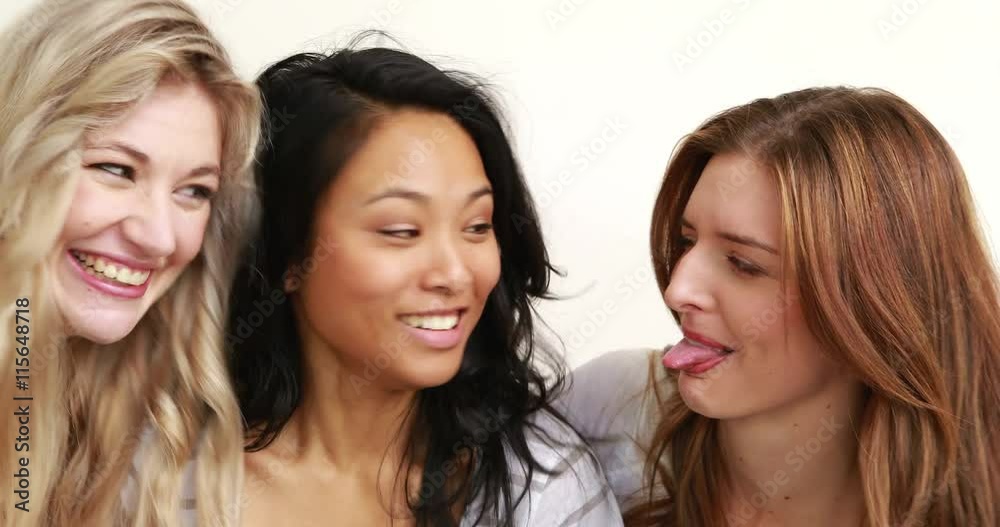 Smiling women making funny faces against white background Smiling women making funny faces against white background