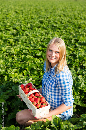 Frau mit Korb voller Erdbeeren