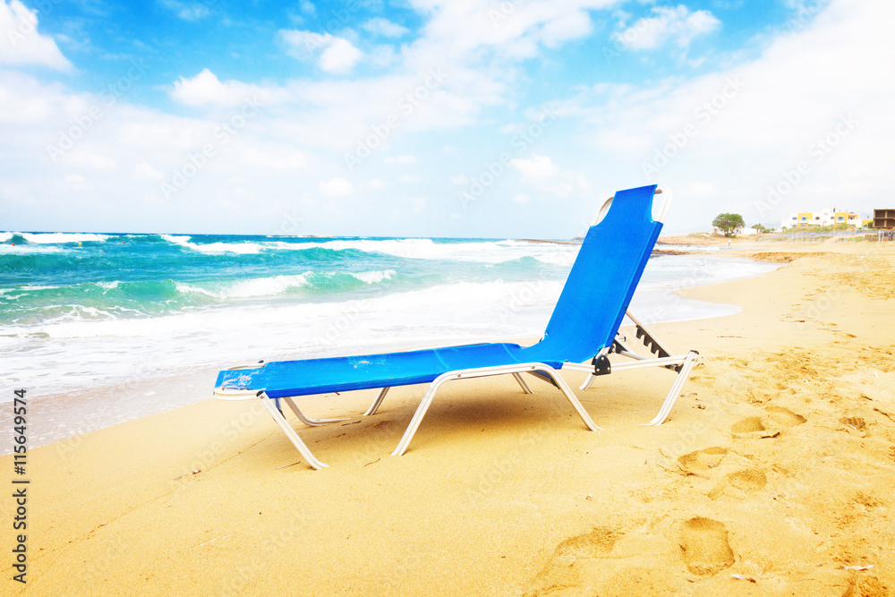 blue chair on Malia beach, Crete Greece, toned - obrazy, fototapety, plakaty 